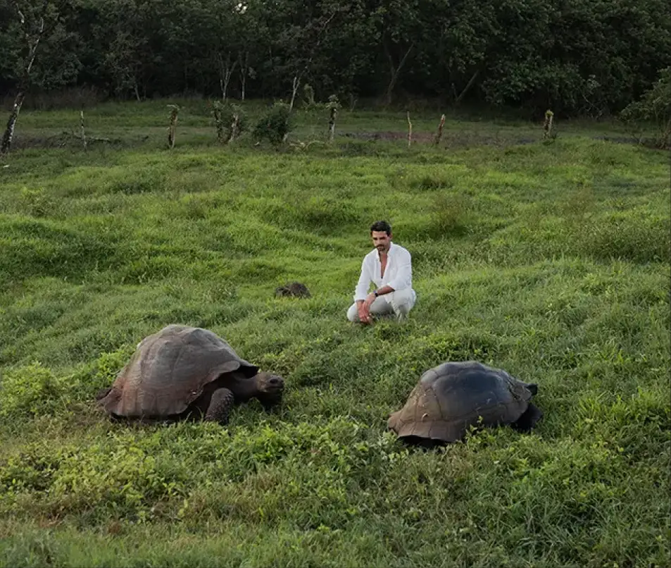 Guest with giant tortoises in the reserve